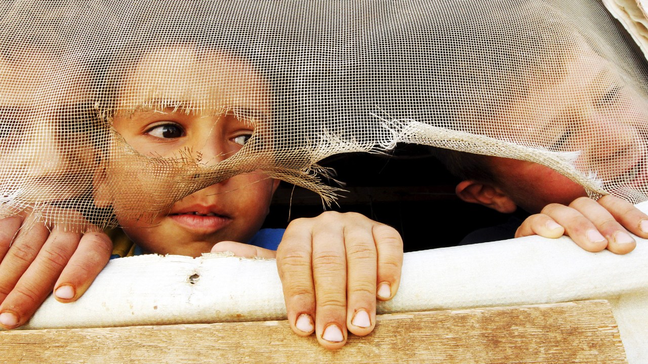 Crianças refugiadas sírias olham para fora de sua tenda durante visita de Stephen O'Brien, diretor de assuntos humanitários da ONU, em Saadnayel no Vale de Bekaa no Líbano