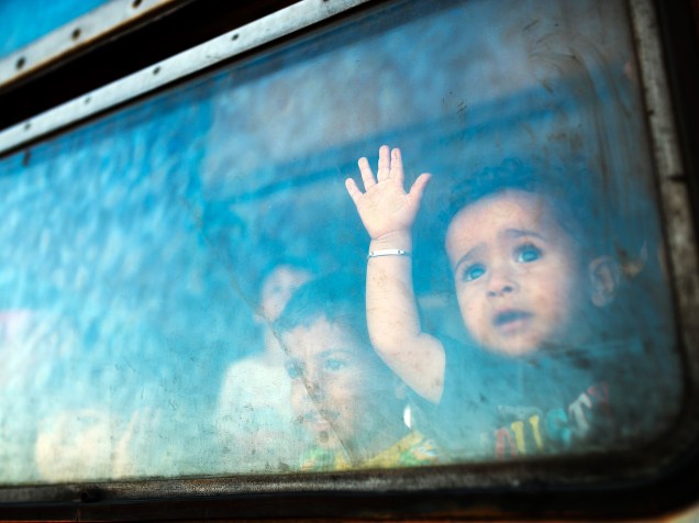 Menino imigrante olha da janela de um trem com destino à Sérvia na fronteira entre a Grécia e a Macedônia, perto da cidade de Gevgelija - 28/08/2015