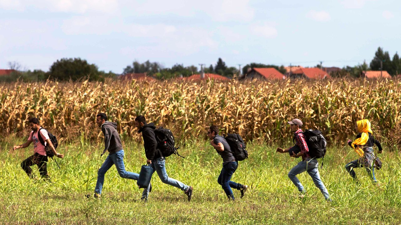 Imigrantes correm da polícia em uma vila de Röszke, Hungria - 08/09/2015