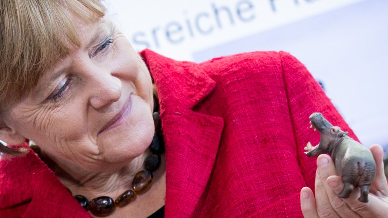 A chanceler alemã Angela Merkel segura um hipopótamo de brinquedo na chancelaria em Berlim, onde recebeu vencedores de uma competição de ciência para jovens - 30/09/2015