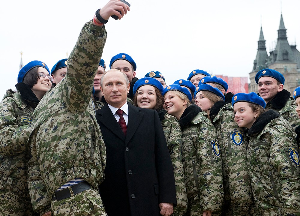 Jovens ativistas fazem selfie com o presidente russo, Vladimir Putin (ao centro), na praça Vermelha, em Moscou, durante as celebrações do Dia da Unidade Nacional. A data comemora o 403º aniversário da expulsão das forças de ocupação polonesas do Kremlin em 1612