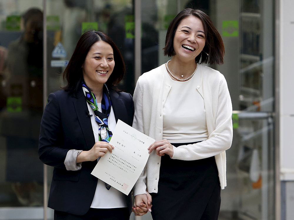 Hiroko Masuhara e a parceira Koyuki Higashi mostram o certificado de união civil ao deixar o escritório do distrito de Shibuya - que faz parte de Tóquio - como o primeiro casal a obter o documento, nesta manhã