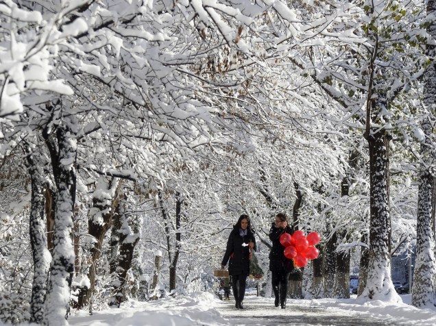 Mulheres andam ao longo de uma rua coberta de neve em Almaty, no Cazaquistão - 16/11/2015