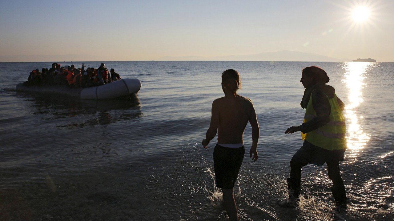 Voluntários se aproximam de uma jangada repleta de imigrantes e refugiados na ilha grega de Lesbos - 17/11/2015