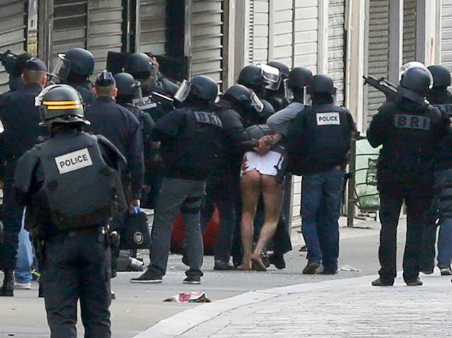 Um homem é levado por policiais durante operação em Saint-Denis, ao norte de Paris, nesta quarta-feira (18). Dois suspeitos morreram e outros sete foram presos na operação antiterrorista