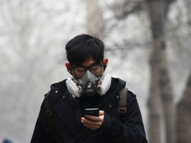 <p>Jovem usa máscara para se proteger da poluição em Pequim, nesta terça-feira (08)</p>
