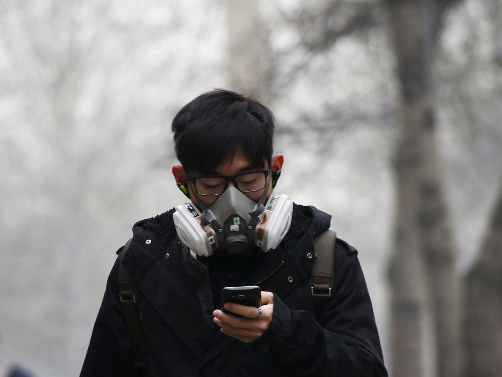 Jovem usa máscara para se proteger da poluição em Pequim, nesta terça-feira (08)