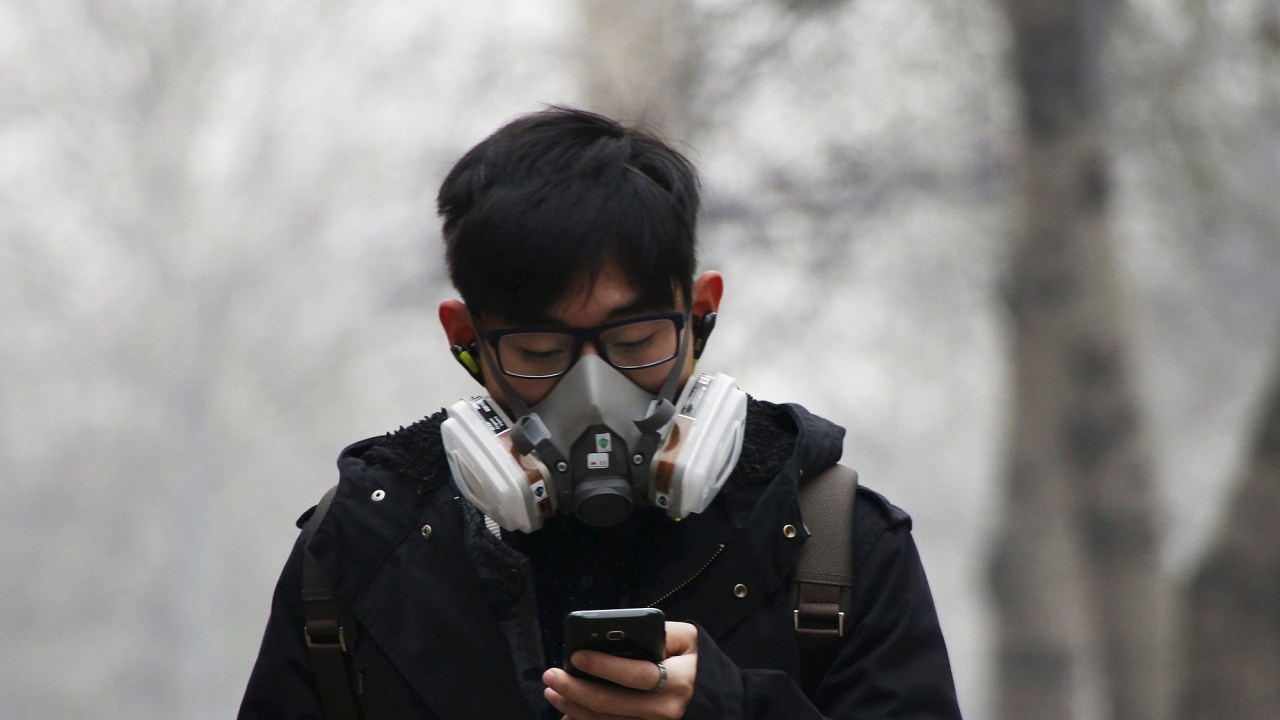 Jovem usa máscara para se proteger da poluição em Pequim, nesta terça-feira (08)