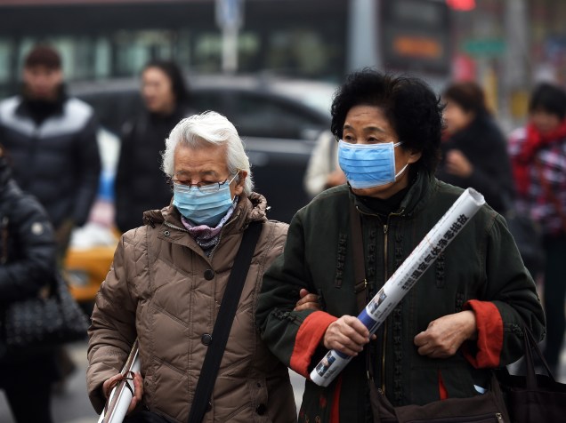 <p>Mulheres usam máscara para se proteger da poluição em Pequim, nesta segunda-feira (14)</p>