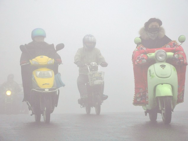 <p>Motociclistas andam pela névoa de poluição na província em Yangzhou, na província de Jiangsu, na China, nesta segunda-feira (21)</p>