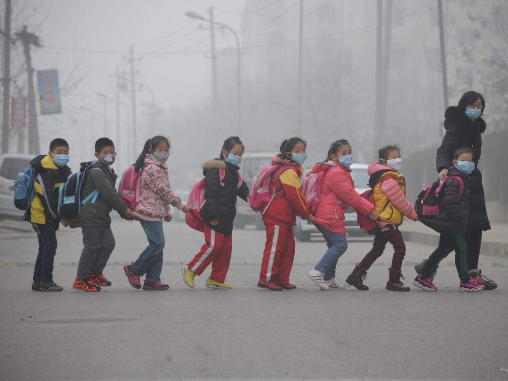 Estudantes usando máscaras devido à poluição atmosférica atravessam uma rua em Jinan, China - 24/12/2015