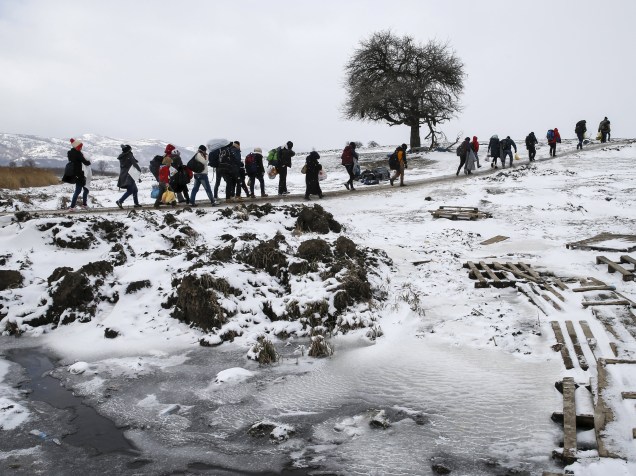 Refugiados atravessam um campo congelado depois de cruzar a fronteira da Macedônia, perto da aldeia de Miratovac, na Sérvia - 18/01/2016