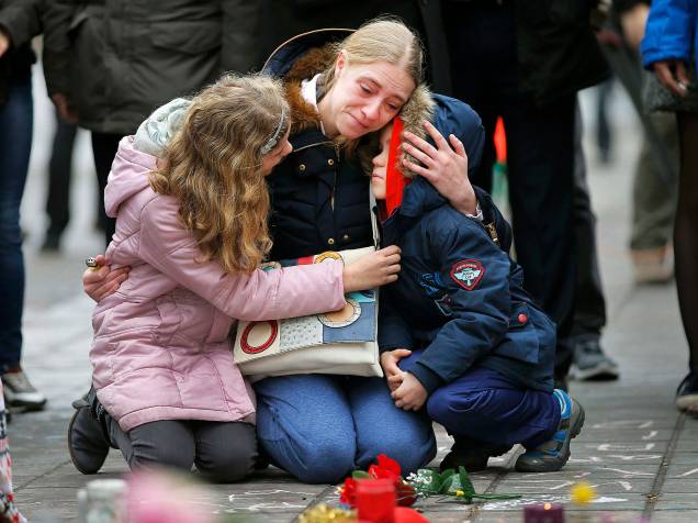 Mulher chora e abraça seus filhos em um memorial às vítimas dos ataques em Bruxelas, na Bélgica