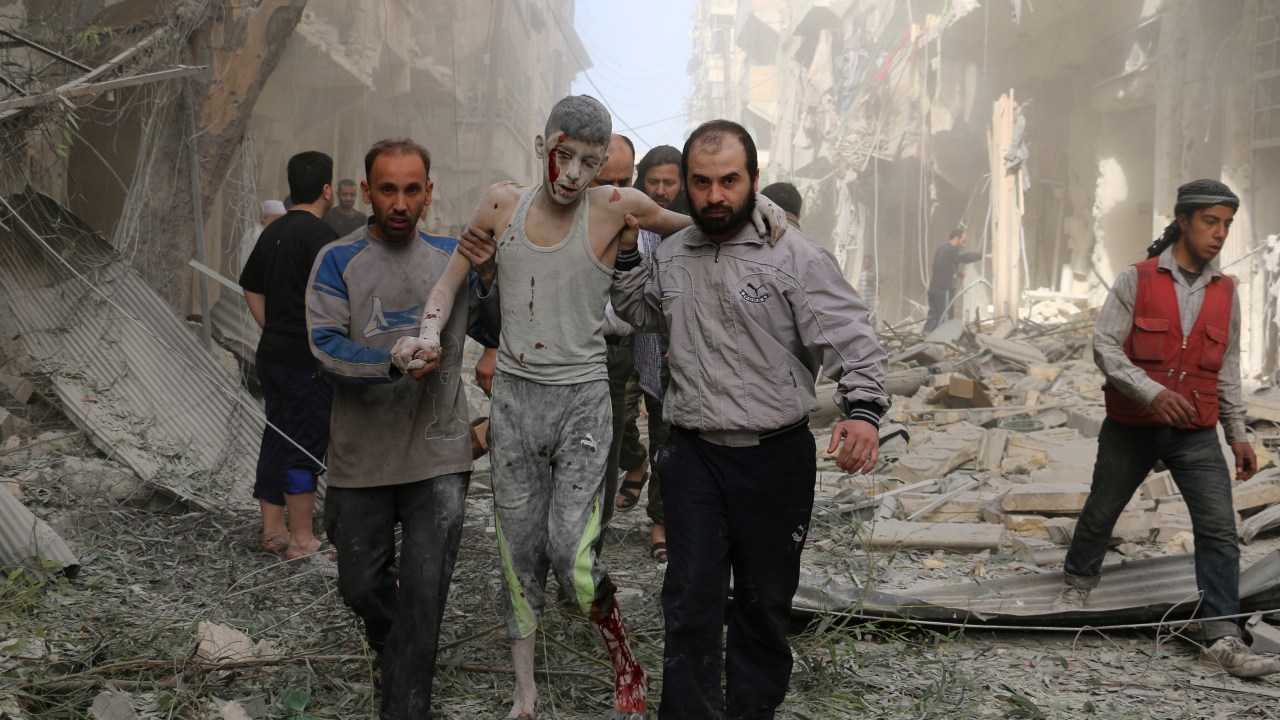Civis socorrem homem ferido após ataque aéreo em Aleppo