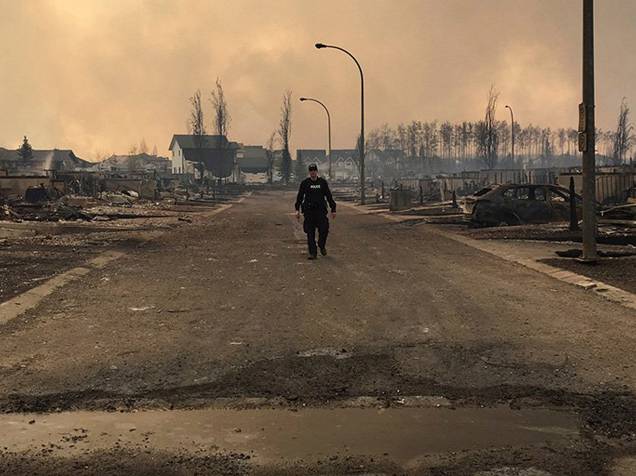 Policial observa os danos causados pelo incêndio florestal que atingiu a região da cidade de Fort McMurray, no Canadá. Cerca de 80 mil pessoas foram evacuadas do local - 05/05/2016