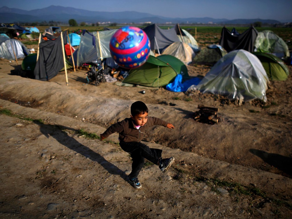 Garoto refugiado brinca com bola na fronteira fechada entre Grécia e Macedônia