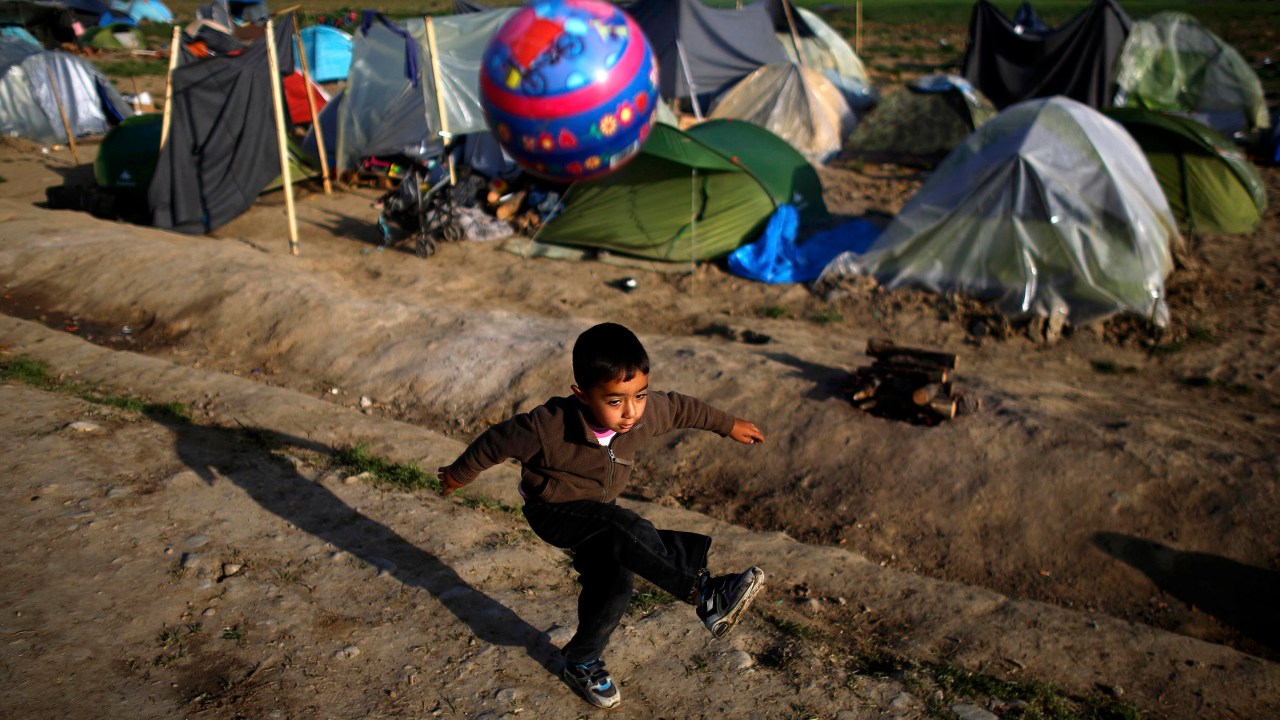 Garoto refugiado brinca com bola na fronteira fechada entre Grécia e Macedônia
