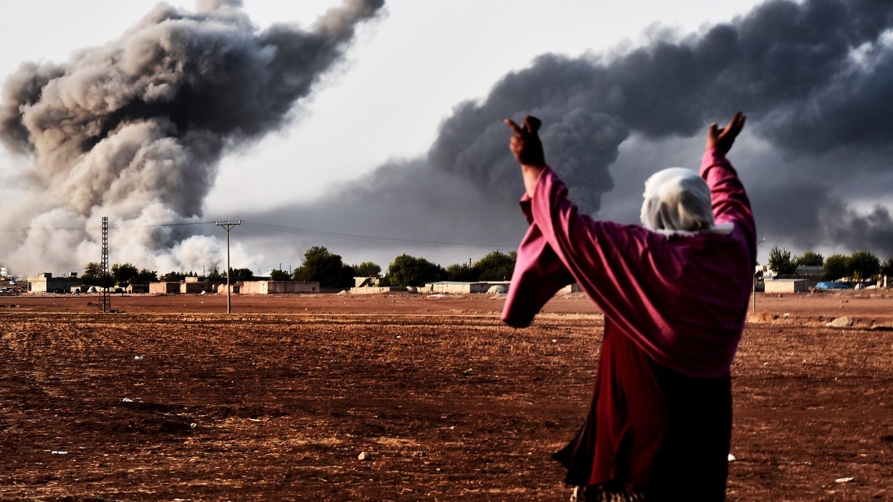 Mulher reage ao ver fumaça na cidade síria de Ain al-Arab, depois de um bombardeio liderado pelos Estados Unidos contra o Estado Islâmico (EI)