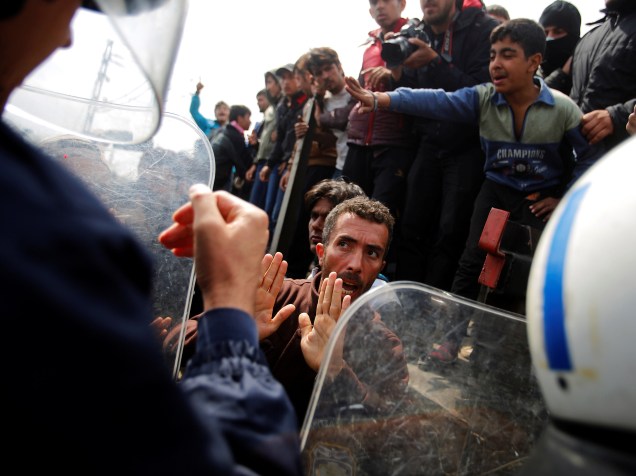 Refugiados sírios lutam contra polícia grega, depois de tentarem derrubar um ônibus da polícia, a fim de entrarem na Macedônia, cujas fronteiras estão fechadas há pelo menos duas semanas - 11/04/2016