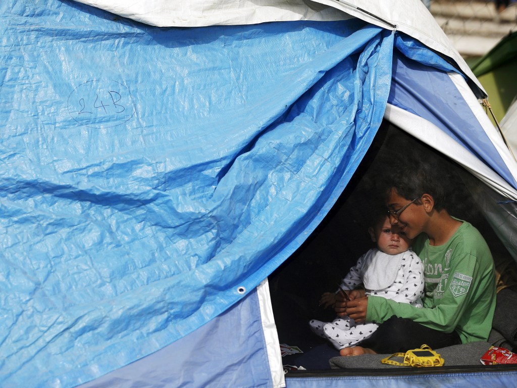 Crianças se abrigam em uma barraca na cidade grega Idomeni