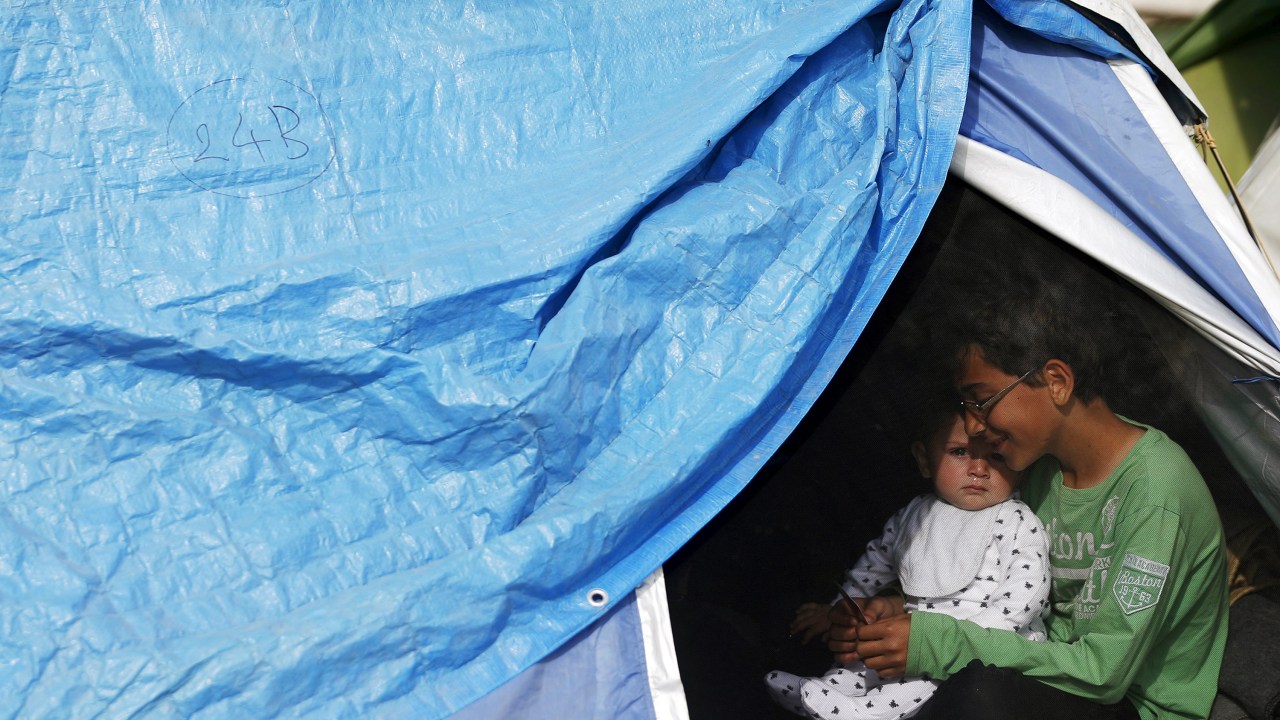 Crianças se abrigam em uma barraca na cidade grega Idomeni