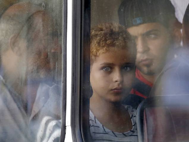 Garoto sírio vítima do naufrágio olha pela janela de um ônibus após chegar em uma base comunitária em Malta