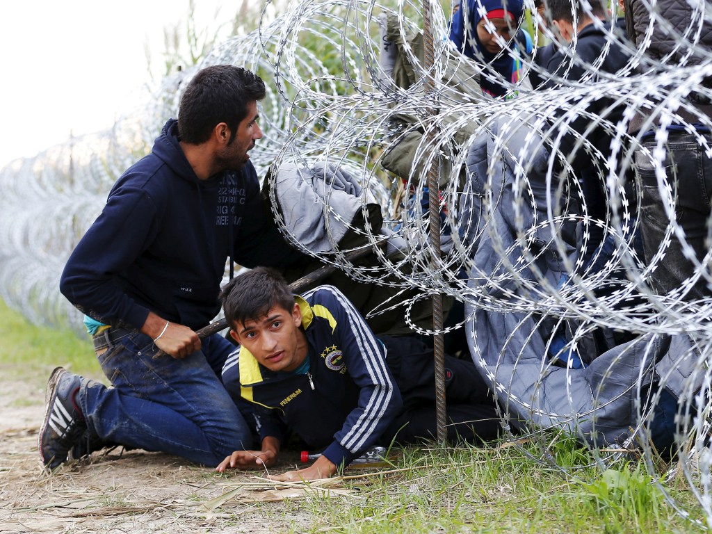 Imigrantes sírios tentam atravessar cerca na fronteira entre a Sérvia e a Hungria. O país iniciou a construção de uma cerca de 175 km na região - 26/08/2015