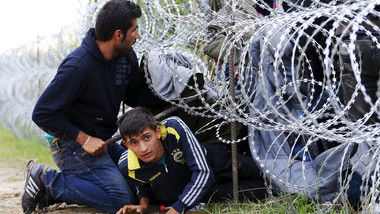 Imigrantes sírios tentam atravessar cerca na fronteira entre a Sérvia e a Hungria. O país iniciou a construção de uma cerca de 175 km na região - 26/08/2015