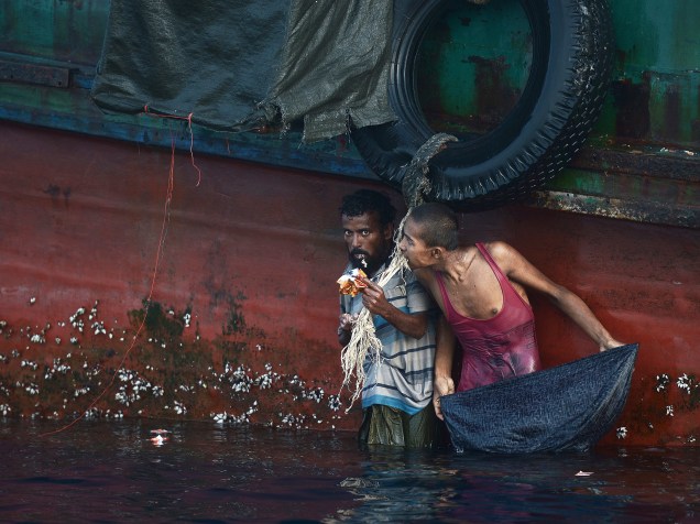 Imigrantes Rohingya se alimentam de mantimentos jogados por helicóptero tailandês