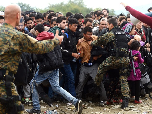 Refugiados tentam entrar em um acampamento na cidade de Gevgelija, na Macedônia, próxima a fronteira com a Grécia, nesta segunda-feira (19)
