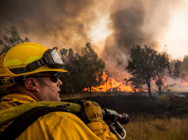 Bombeiro tenta controlar as chamas do incêndio que ficou conhecido como "Rocky Fire", em Clearlake, Califórnia
