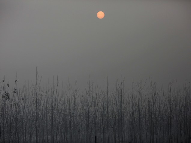 <p>O sol é visto através da poluição em uma entrada entre Pequin e Hebei, na China</p>