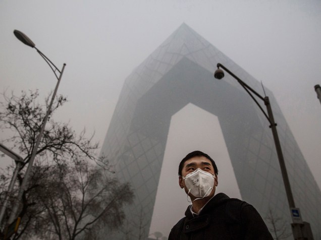 <p>Homem anda com másacara no centro de Pequim, na China</p>