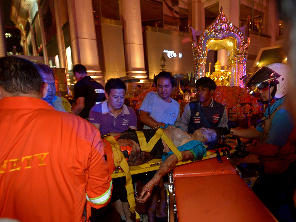 Mulher é socorrida após explosão de uma bomba no centro de Bangcoc, na Tailândia