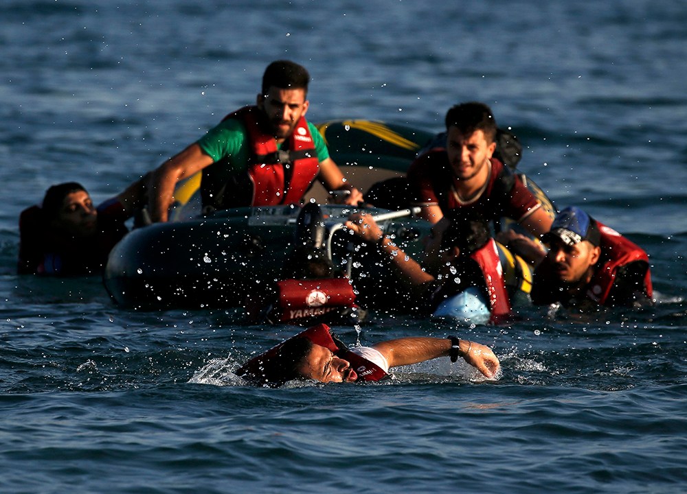 Refugiado vindo da Turquia e da Síria nada antes de chegar à costa da ilha de Kos, na Grécia