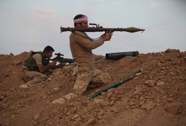 Soldado das forças curdas Peshmerga se prepara para lançar um foguete contra jihadistas, no Iraque