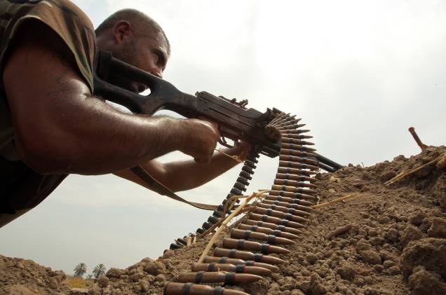 Combatente xiita monta guarda próximo à cidade de Bagdá contra os jihadistas do Estado Islâmico, no Iraque