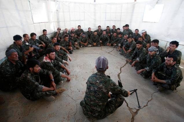 Voluntários yazidis durante instruções de como manusear armas para combater terroristas no Iraque