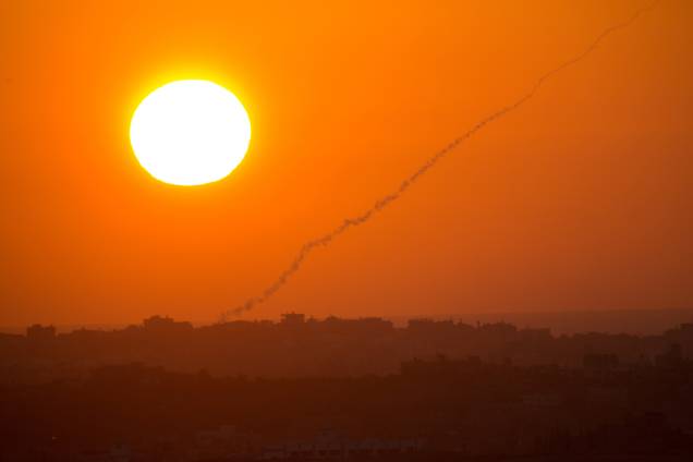 Uma foto tirada do lado israelense da fronteira Israel-Gaza nesta quarta-feira (20), mostra o rastro de fumaça de um foguete disparado por militantes palestinos da Faixa de Gaza contra Israel. A região rompeu com o cessar-fogo que já durava cinco dias