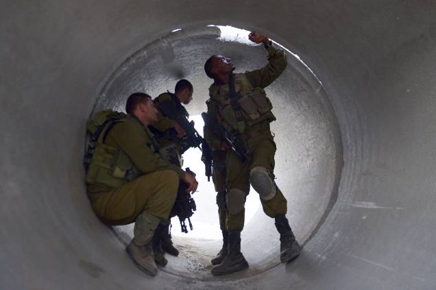 Soldados israelenses são fotografados enquanto se escondem em um cilindro de cimento, aos arredores da Faixa de Gaza, em 20/08/2014