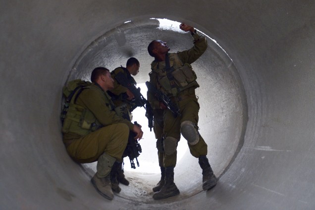 Soldados israelenses são fotografados enquanto se escondem em um cilindro de cimento, aos arredores da Faixa de Gaza, em 20/08/2014