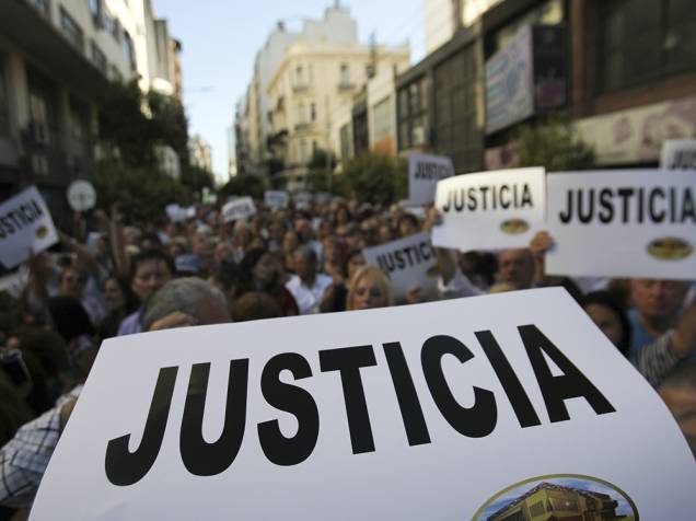 Dezenas de pessoas seguram cartazes durante uma manifestação nesta quarta-feira (21) para exigir justiça após a morte do promotor argentino Alberto Nisman, em frente à sede da Associação Mutual Israelita Argentina, em Buenos Aires