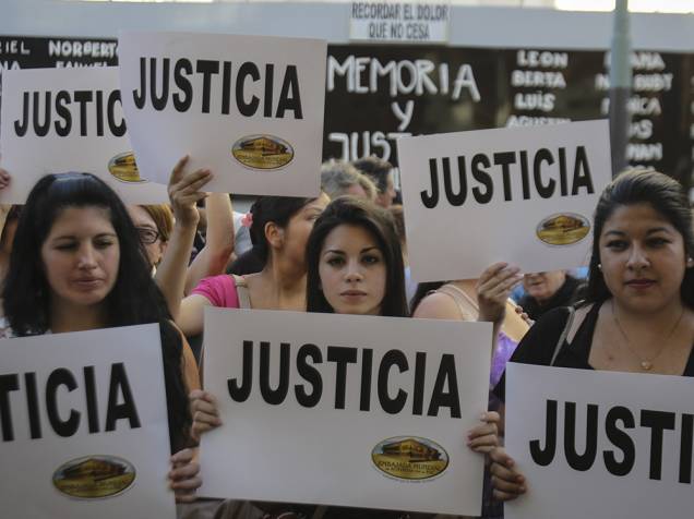 Dezenas de pessoas seguram cartazes durante uma manifestação nesta quarta-feira (21) para exigir justiça após a morte do promotor argentino Alberto Nisman, em frente à sede da Associação Mutual Israelita Argentina, em Buenos Aires