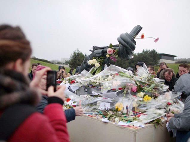 Pessoas depositam flores ao pé de uma escultura do artista sueco Carl Frederik Reutersward, como um memorial em homenagem às vítimas do terrorismo que assolou a França nos últimos dias, na cidade de Caen