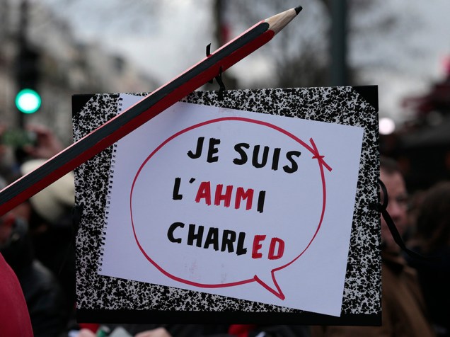 Cartaz em homenagem ao policial morto durante ato terrorista em Paris é visto durante marcha deste domingo (11)