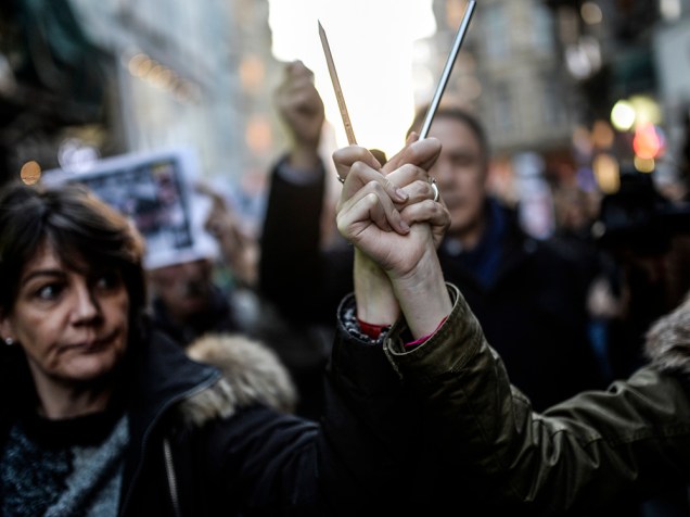Dezenas de pessoas seguraram lápis e cartazes de apoio aos franceses, durante ato na avenida Istiklal, em Istambul, na Turquia