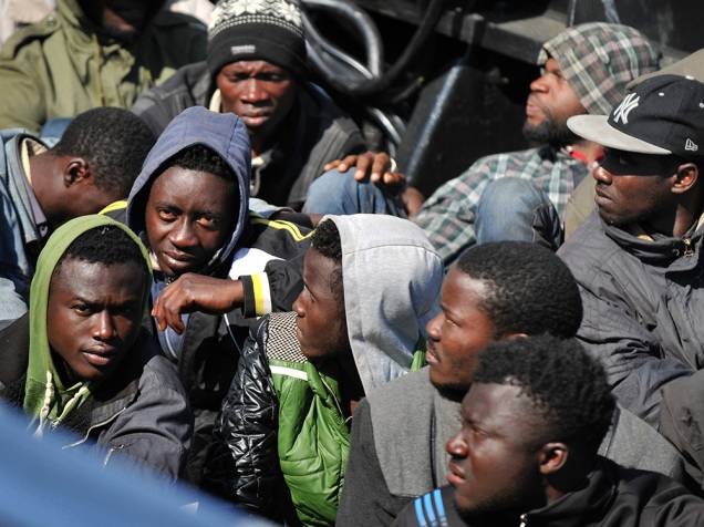 Grupo de imigrantes que sobreviveram a naufrágio aguardam por atendimento médico no porto de Corigliano Calabro, na Itália