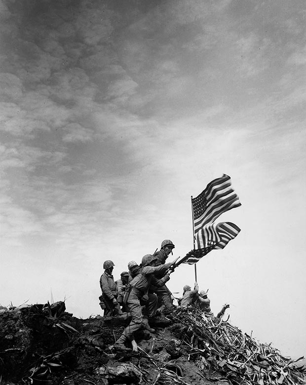 Bandeira americana no monte Suribachi. Na foto, soldados americanos trocam a bandeira antiga por uma maior. Batalha de Iwo Jima durante a Segunda Guerra Mundial – 1945