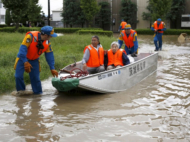 Moradores são resgatados por policiais em uma área inundada após a passagem do tufão Etau em Ibarak, no Japão