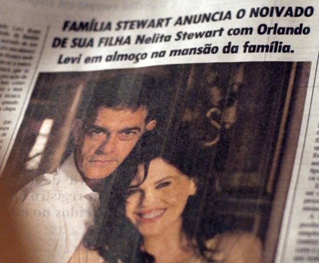 Orlando (Eduardo Moscovis) e Nelita (Bárbara Paz) em coluna social de jornal, achado por Lara (Carolina Dieckmann)